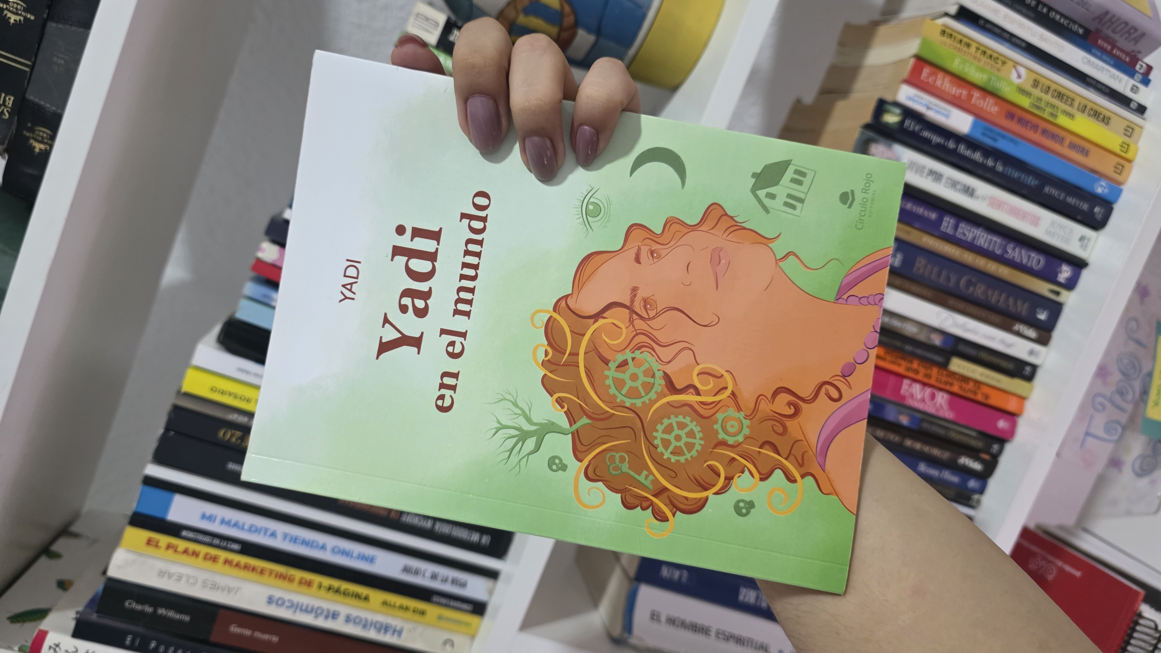 El libro de Yadi junto a mi estantería de libros.